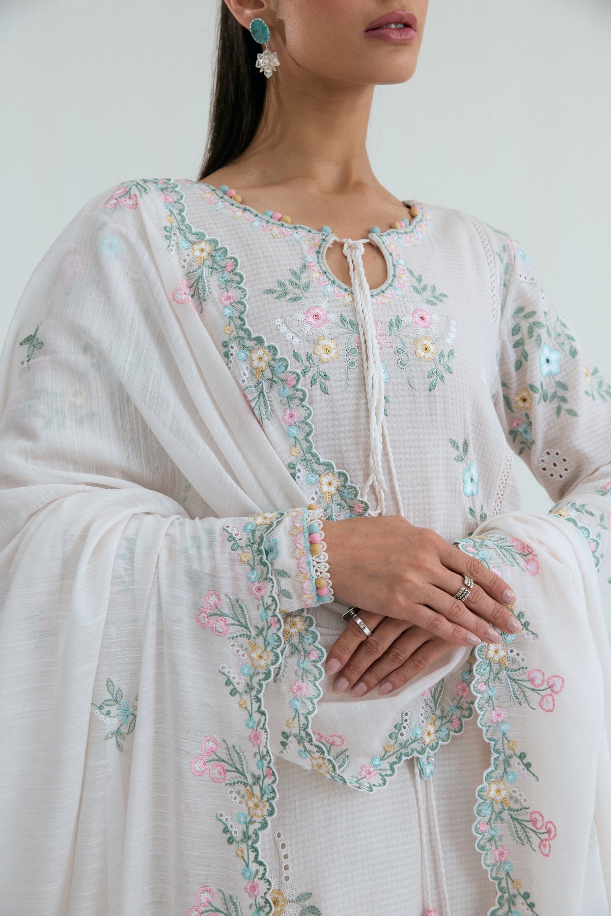 Floral cutwork embroidery detail on off-white Pakistani cotton kameez