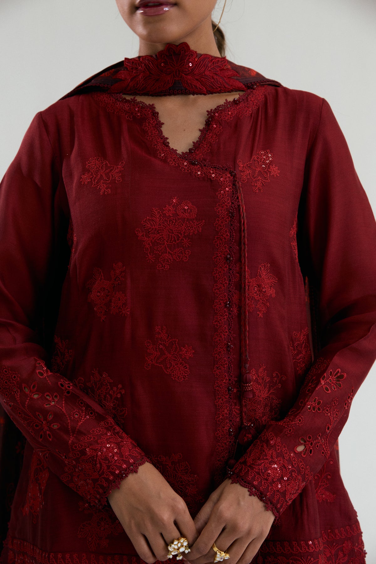Close-up view of deep red Pakistani raw silk angrakha set with flared trousers and printed silk dupatta by Mannam