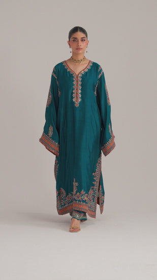 The Afroz Set is a teal blue pure silk Pakistani phiran featuring Kashmiri-inspired embroidery, ajrak print accents, tassel sleeves, and pockets